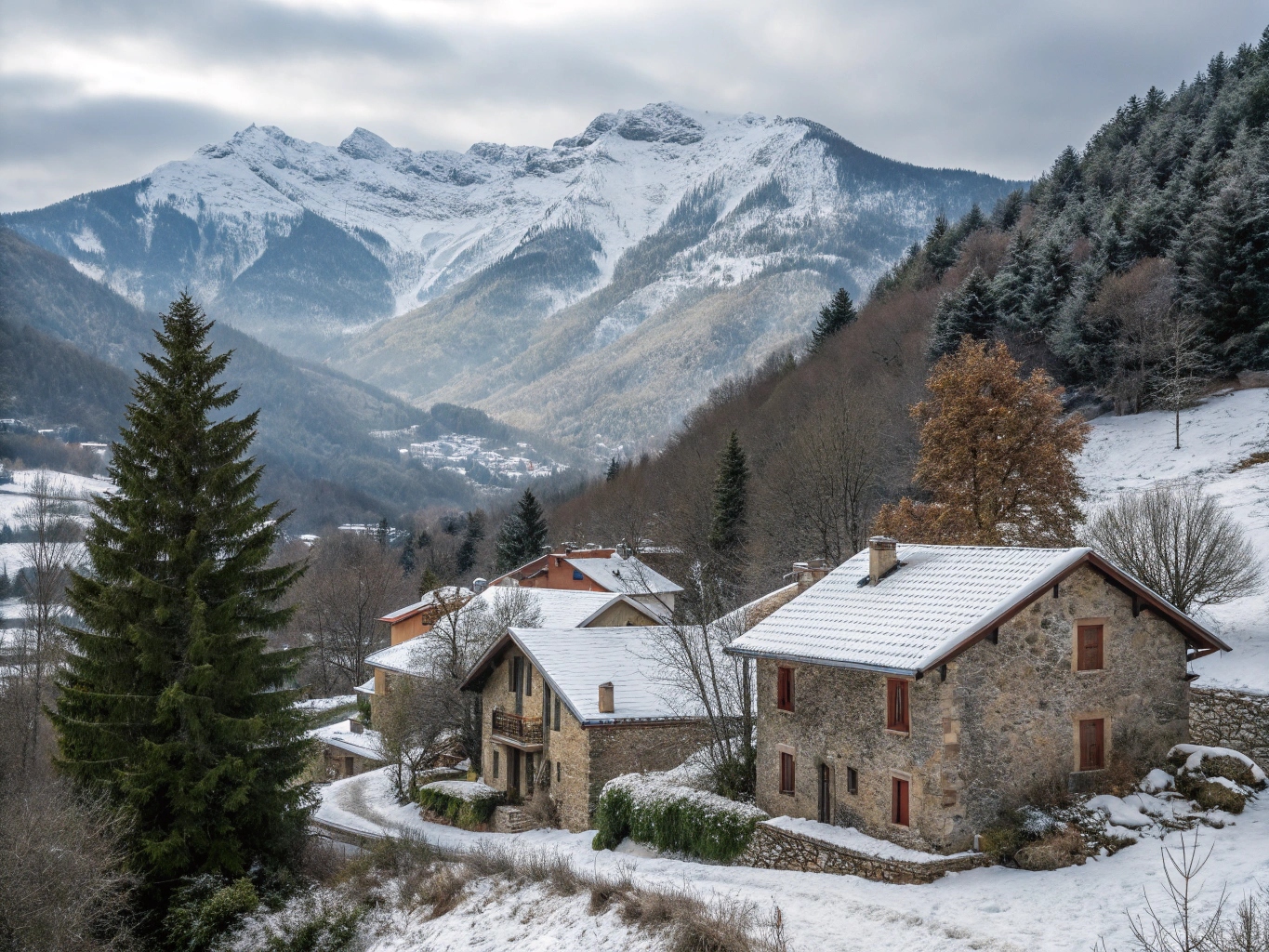 Paysage hivernal ariégeois avec maisons traditionnelles en pierre et montagnes enneigées, illustrant les défis climatiques spécifiques à la région.